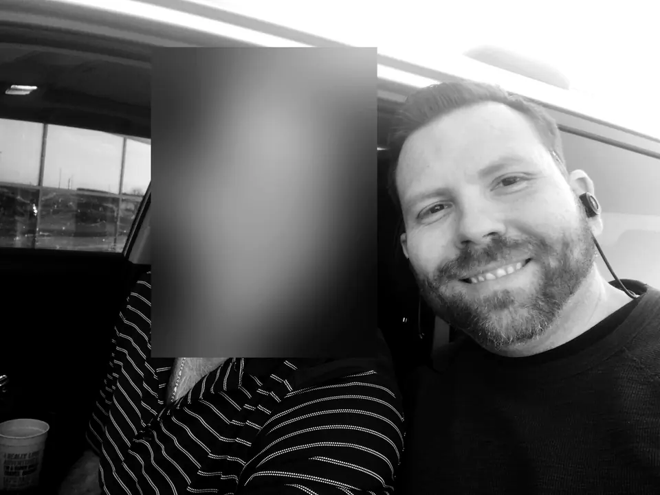 Craig Smith in a vehicle with a colleague; colleague’s face obscured